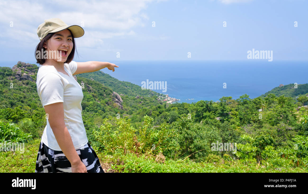 Frauen Touristen zeigen mit dem Finger auf das Meer und den offenen Mund auf hohen Standpunkt aus die schöne Natur Landschaft von Koh Tao Insel zu sehen ist eine berühmte att Stockfoto