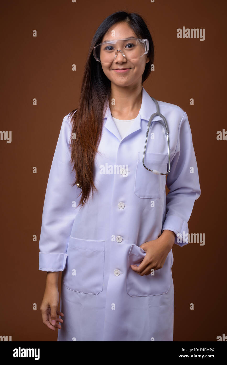 Junge schöne asiatische Frau Doktor tragen Schutzbrille ag Stockfoto