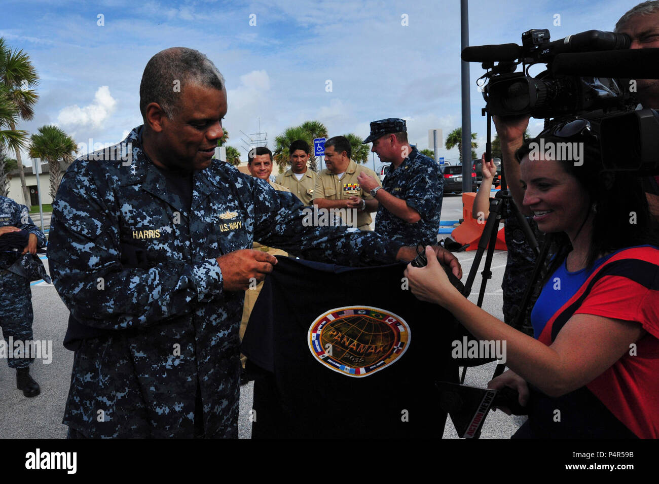 U.S. Navy hinten Adm. Sinclair Harris, Links, dem Kommandeur der US-Flotte, gibt Panamax militärische Übung T-Shirts nach Jacksonville, Fla., Medien während einer Pressekonferenz aus Panamax 2012 Naval Station Mayport, Fla., Nov. 6, 2012 zu treten. Panamax ist eine jährliche US Southern Command - geförderte gemeinsame Ausübung der Serie, die auf die Gewährleistung der Verteidigung von Panama durch Leben und simulierten Szenarios vor der Küste von Panama und Standorten in den Vereinigten Staaten konzentriert. (DoD Stockfoto