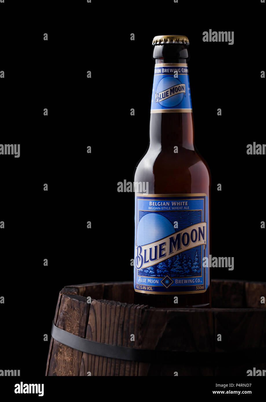LONDON, UK - Juni 06, 2018: Flasche Blue Moon belgischen Weißbier, durch MillerCoors auf alten Holzfass auf schwarzem Hintergrund gebraut. Stockfoto
