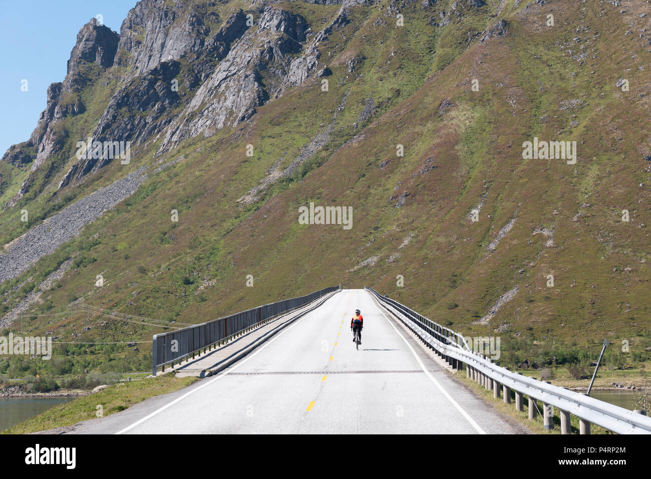 Radfahrer reiten Gimsøystraumbrua Brücke, Lofoten, Norwegen. Stockfoto