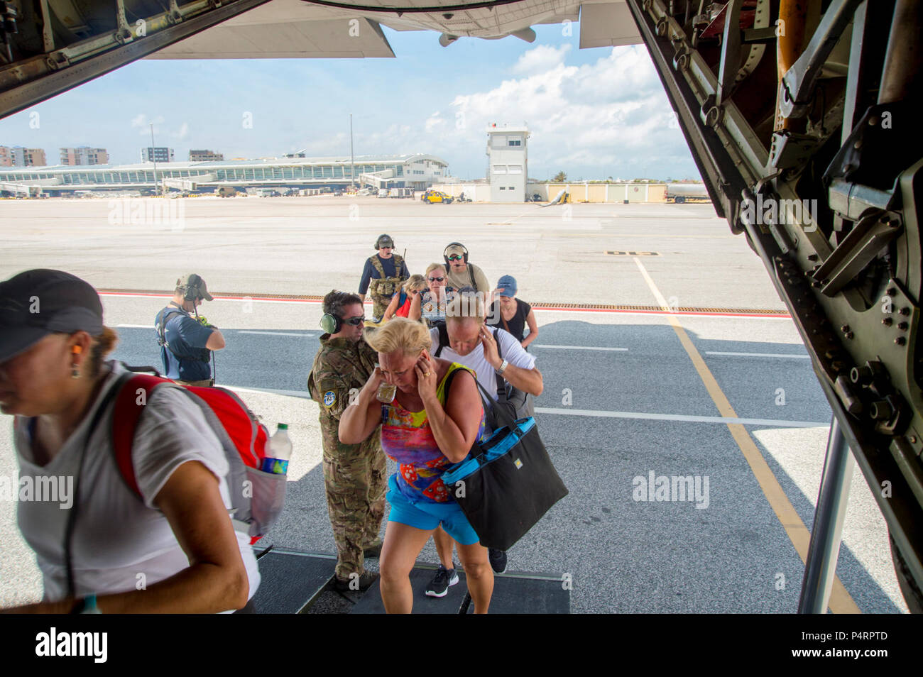 Mitglieder aus der 106 Rettung Flügel helfen Evakuierten von Princess Juliana International Airport auf St. Maarten auf den HC-130 nach San Juan, Puerto Rico, geleitet. 106 Rettung der New York Air National Guard Flügel, die Inszenierung von San Juan, Puerto Rico mit der 156 Air Lift Flügel bieten Rescue Support für die Bedürftigen auf St. Maarten. Die 106 zwei HC-130 König Flugzeug gebracht, drei HH-60 Pave Hawk Hubschrauber, drei Sternzeichen Boote und 124 Flieger, die erforderlich sind, um die Mission zu erfüllen. Stockfoto