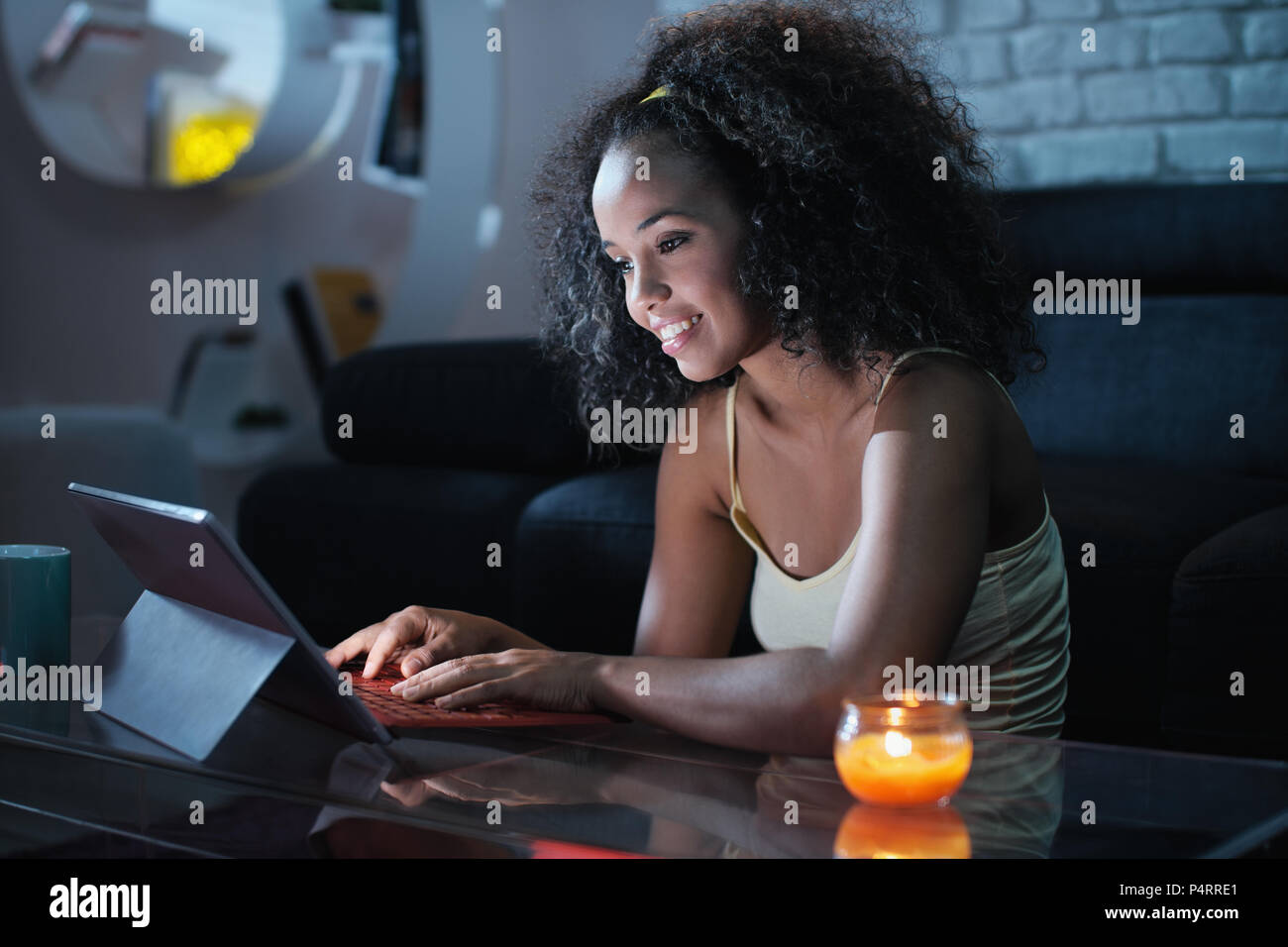Junge Latina Frau eingeben Nachricht auf dem Laptop bei Nacht Stockfoto