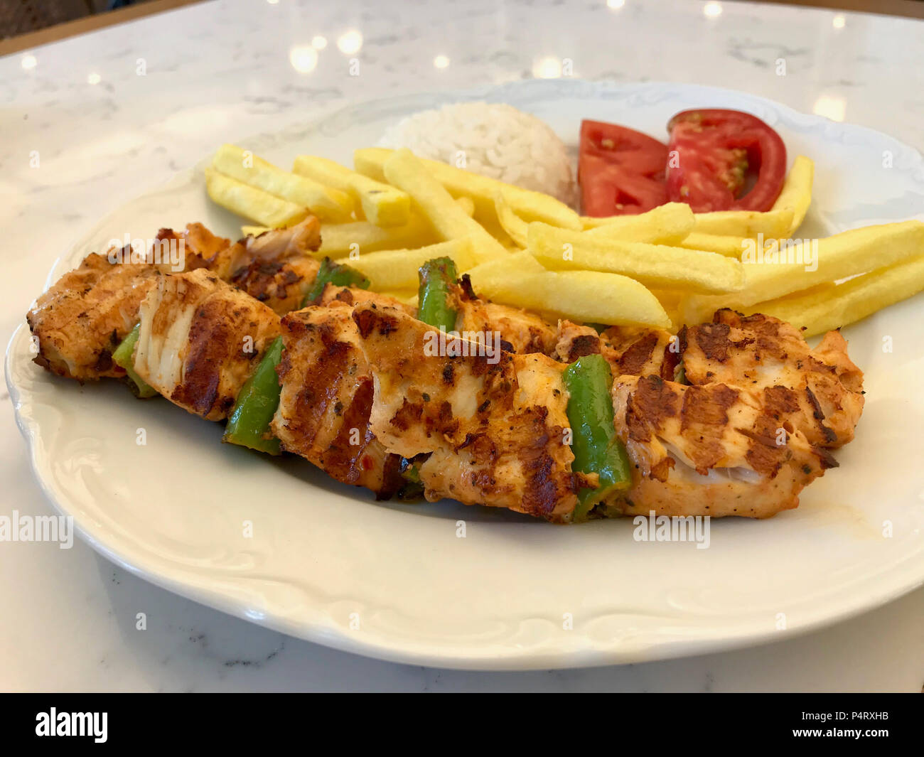 Türkische Hühnchen Shish Kebab mit Reis (pilav oder pilav) Kartoffeln und Tomaten/Sis Kebap. Traditionelle Speisen. Stockfoto