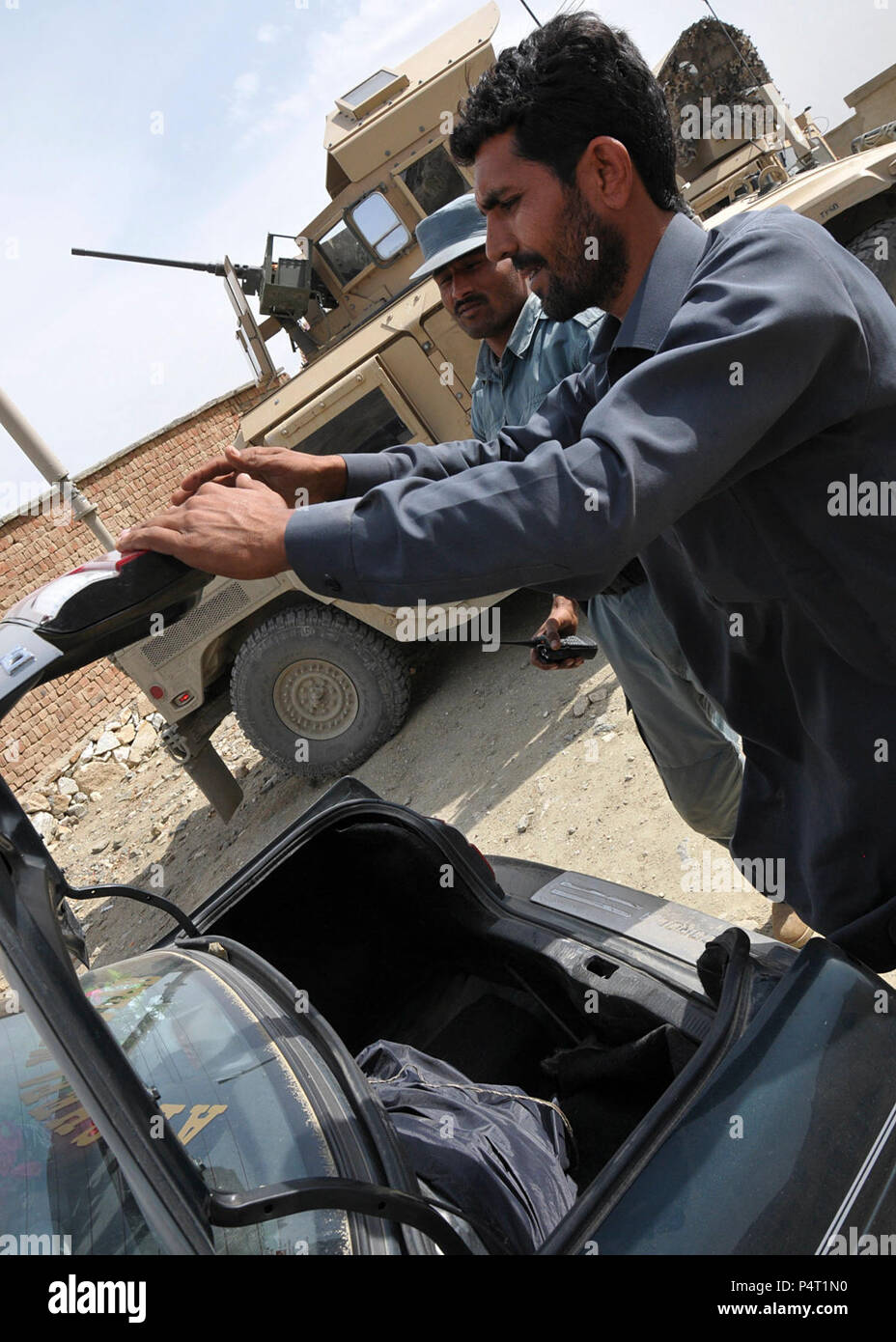 KABUL - (April 1, 2012) der afghanischen nationalen Polizei Offizier Sahab Shak prüft ein Fahrzeug für Drogen, Waffen und anderen illegalen Materialien zu einem routinemäßigen Checkpoint in Northern Kabul als Koalition Berater von Task Force Cujo Standby zu unterstützen. Task Force Cujo besteht aus 28 Männern und Frauen aus der Oregon 1186th Militär Polizei Army National Guard. Die NATO Training Mission-Afghanistan ist eine Koalition von 38 Truppensteller Nationen mit Unterstützung der Regierung der Islamischen Republik Afghanistan zum Generieren einer leistungsfähigen und nachhaltigen der afghanischen nationalen Sicherheitskräfte bereit, Lea zu nehmen aufgeladen Stockfoto