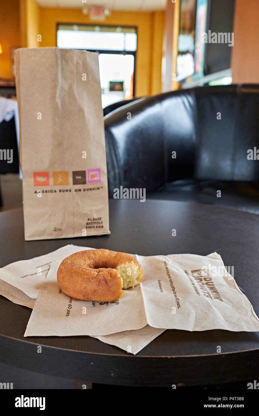 Beutel mit Donuts oder Krapfen mit einer Ebene ganz oder teilweise gegessen Donut auf eine Serviette bei Dunkin Donuts Laden oder Speichern in Montgomery Alabama, USA. Stockfoto