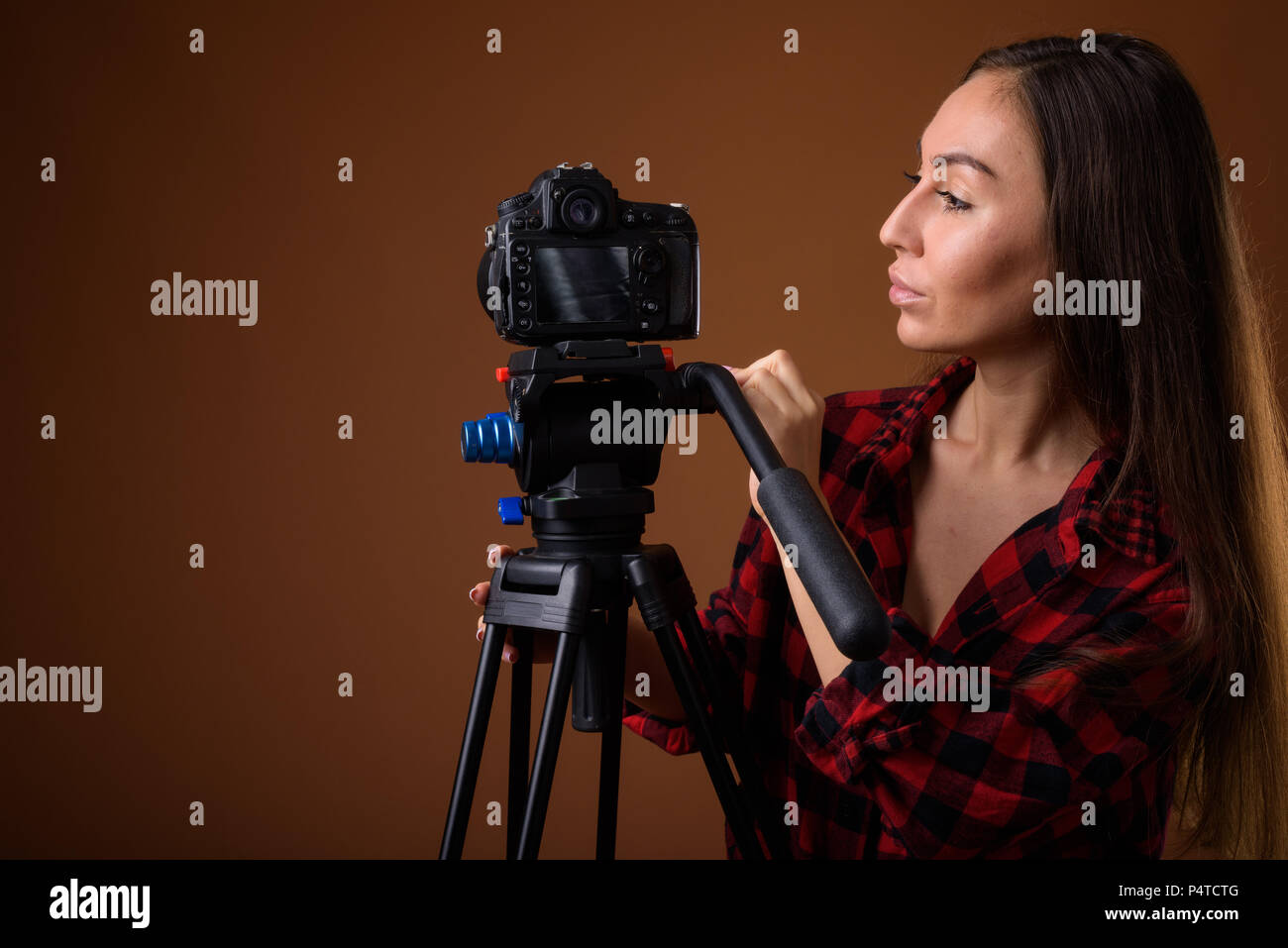 Studio shot der jungen schönen Frau vlogging gegen Braun zurück Stockfoto