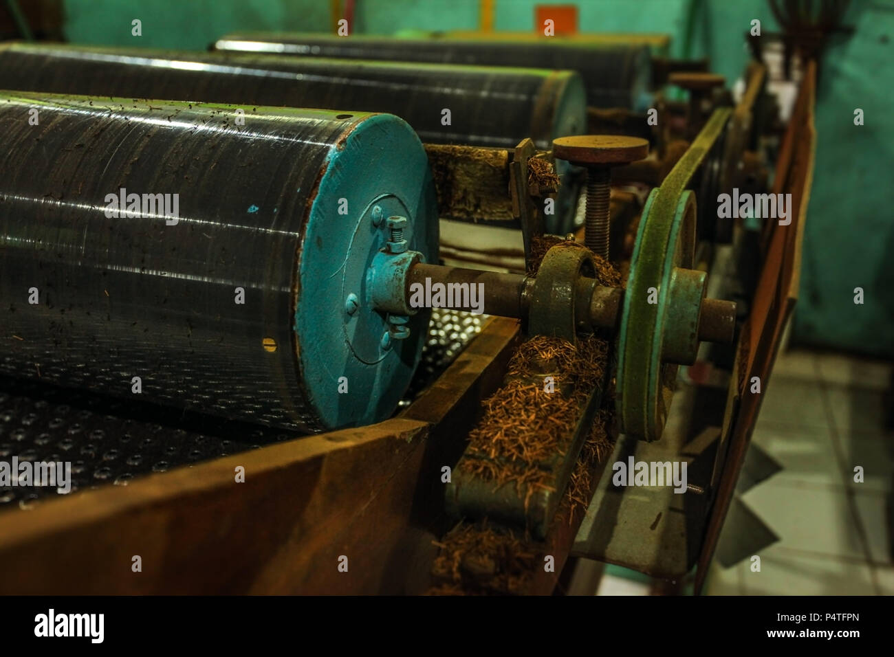 Schwere Rolle Maschine in Kaffee Verarbeitung Fabrik, einige getrocknete Blätter auf rostigen Gerät teilen. Stockfoto