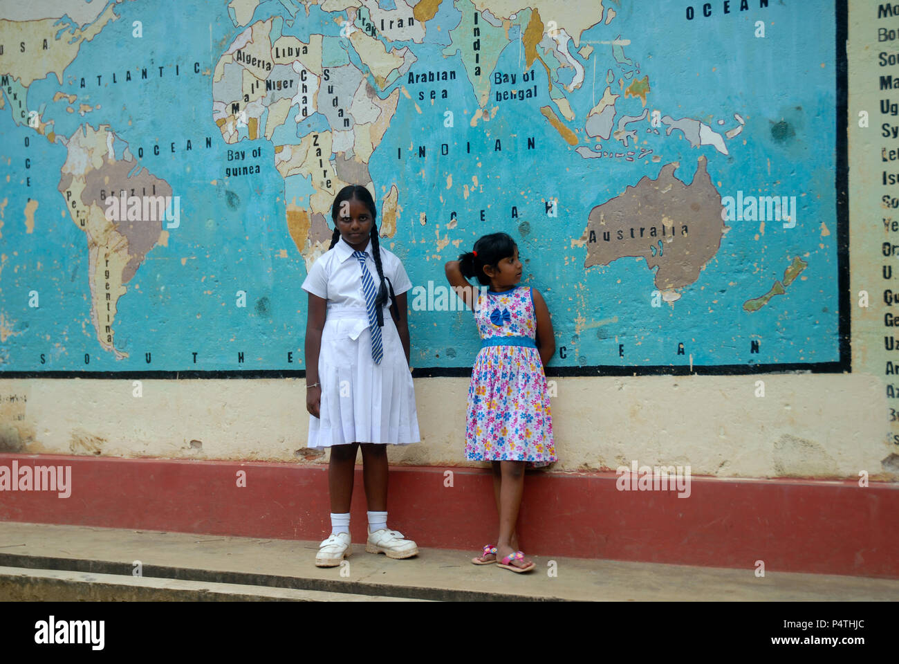 Zwei Schulmädchen, die sich eine Karte ansehen, die an der Wand der Schule gemalt ist, Lankathilaka Maha Vidyalaya, Kovilakanda, Sri Lanka. Stockfoto