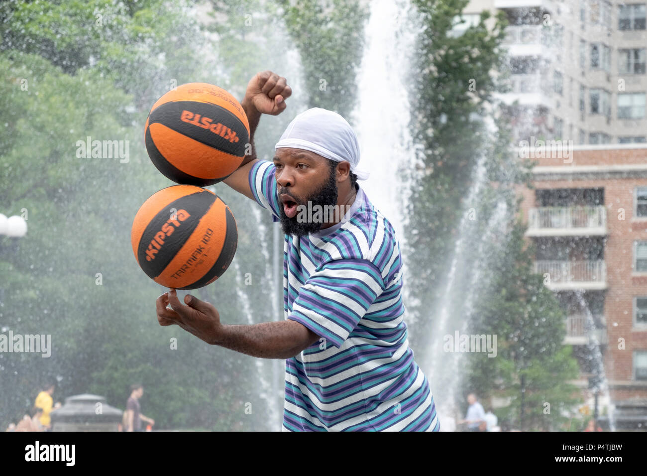 Basketball Mann, ein New York City Street Performer, Salden 2 spinning Basketbälle auf einem Finger. In den Washington Square Park. Stockfoto