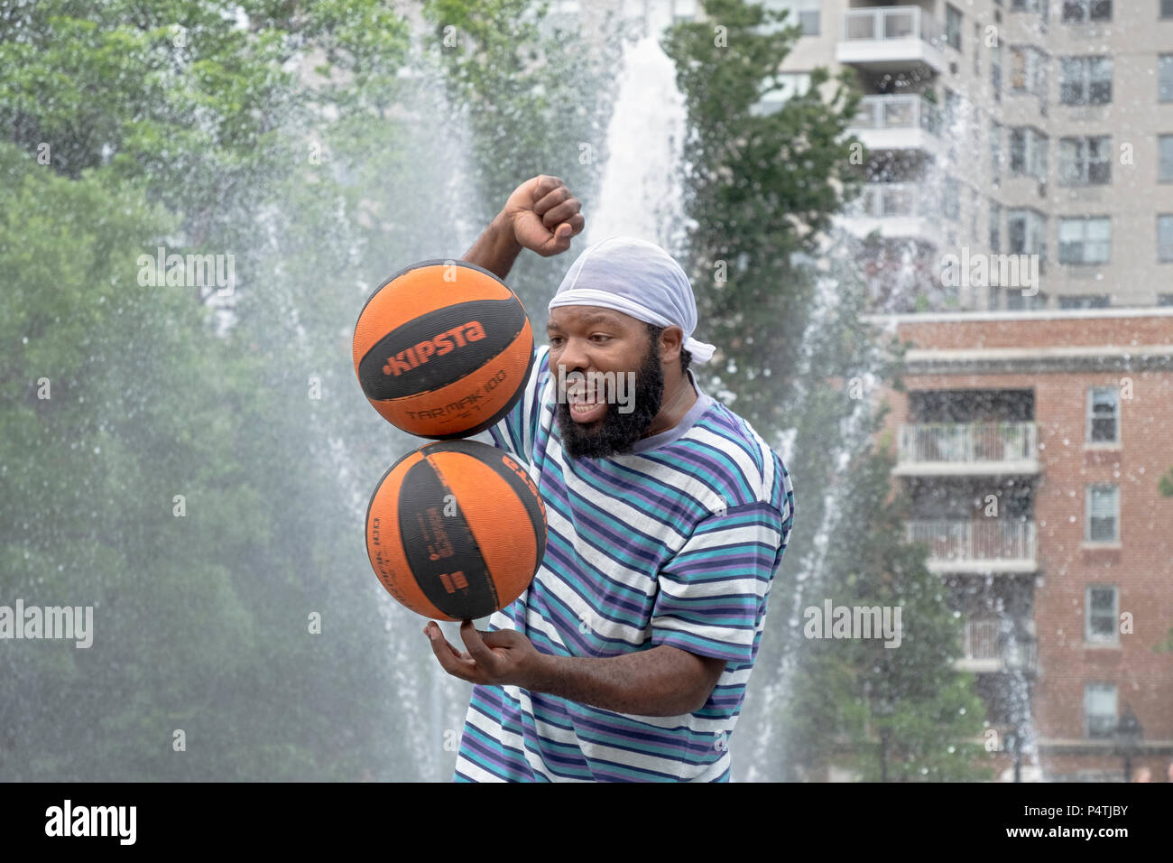 Basketball Mann, ein New York City Street Performer, Salden 2 spinning Basketbälle auf einem Finger. In den Washington Square Park. Stockfoto