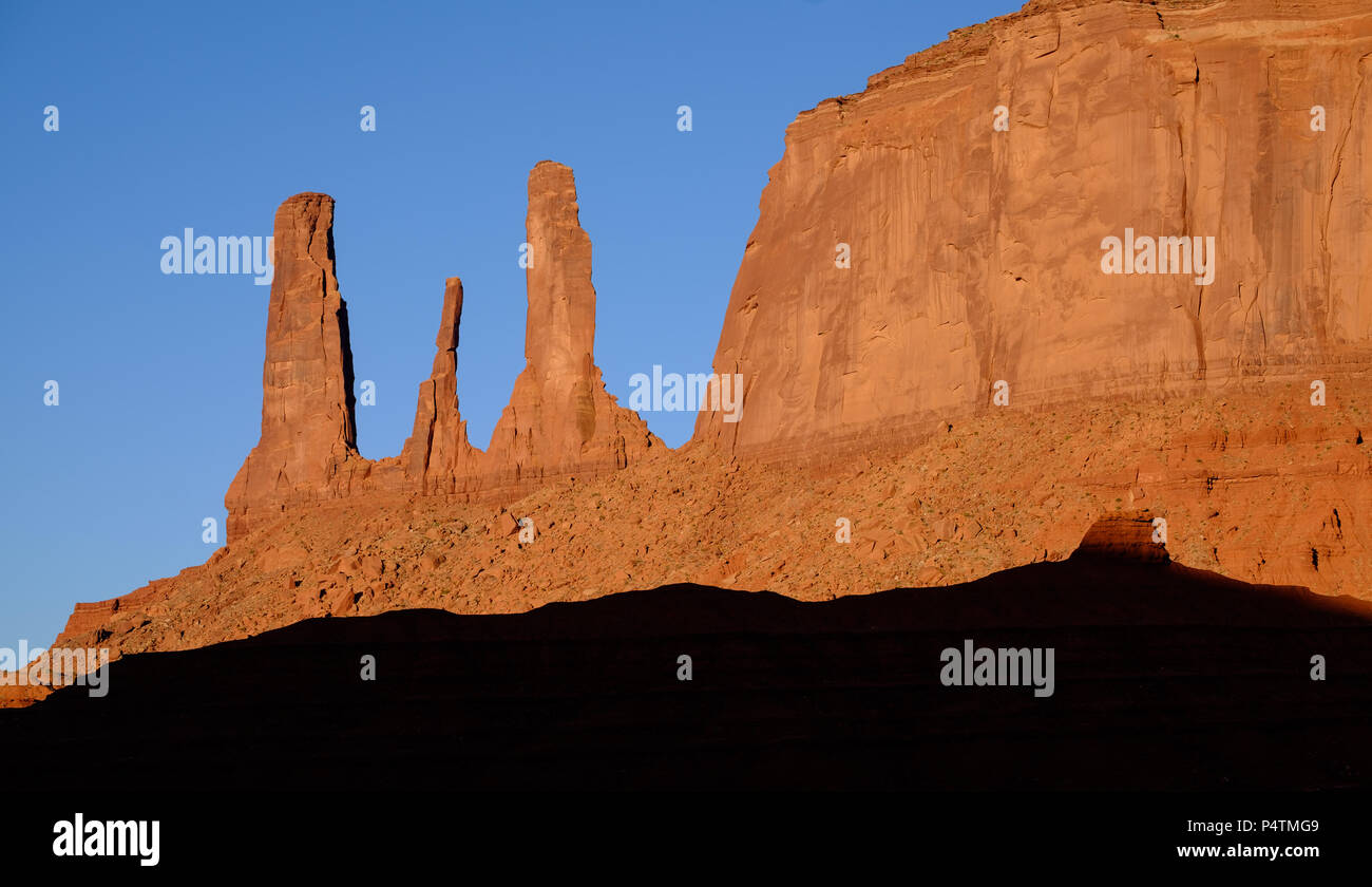 Die drei Säulen an der südöstlichen Ecke der Mitchell Mesa im Monument Valley sind als die drei Schwestern bekannt. Dieses Bild wurde bald nach der Dämmerung erfasst Stockfoto