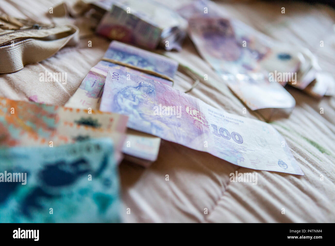 Ausländisches Geld, argentinischen Pesos, verbreitet sich auf ein Hotel Zimmer Bed Stockfoto