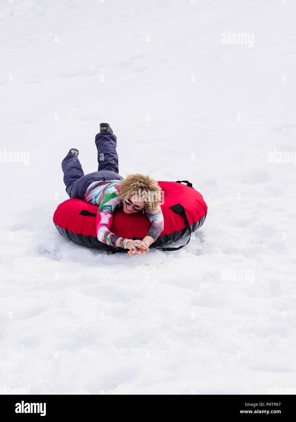 Eine Frau, Snow Tubing, einem Hügel. Stockfoto