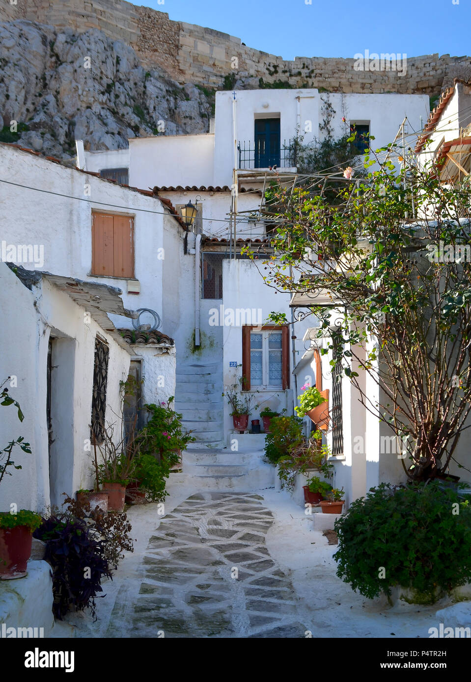 Malerische Straße in Plaka, Athens mit den Wänden der Akropolis hinter Stockfoto