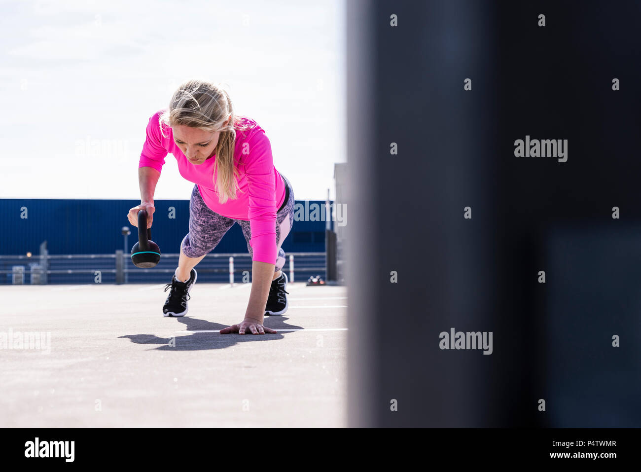 Frau Training mit Hanteln, einarmige Liegestütz Stockfoto