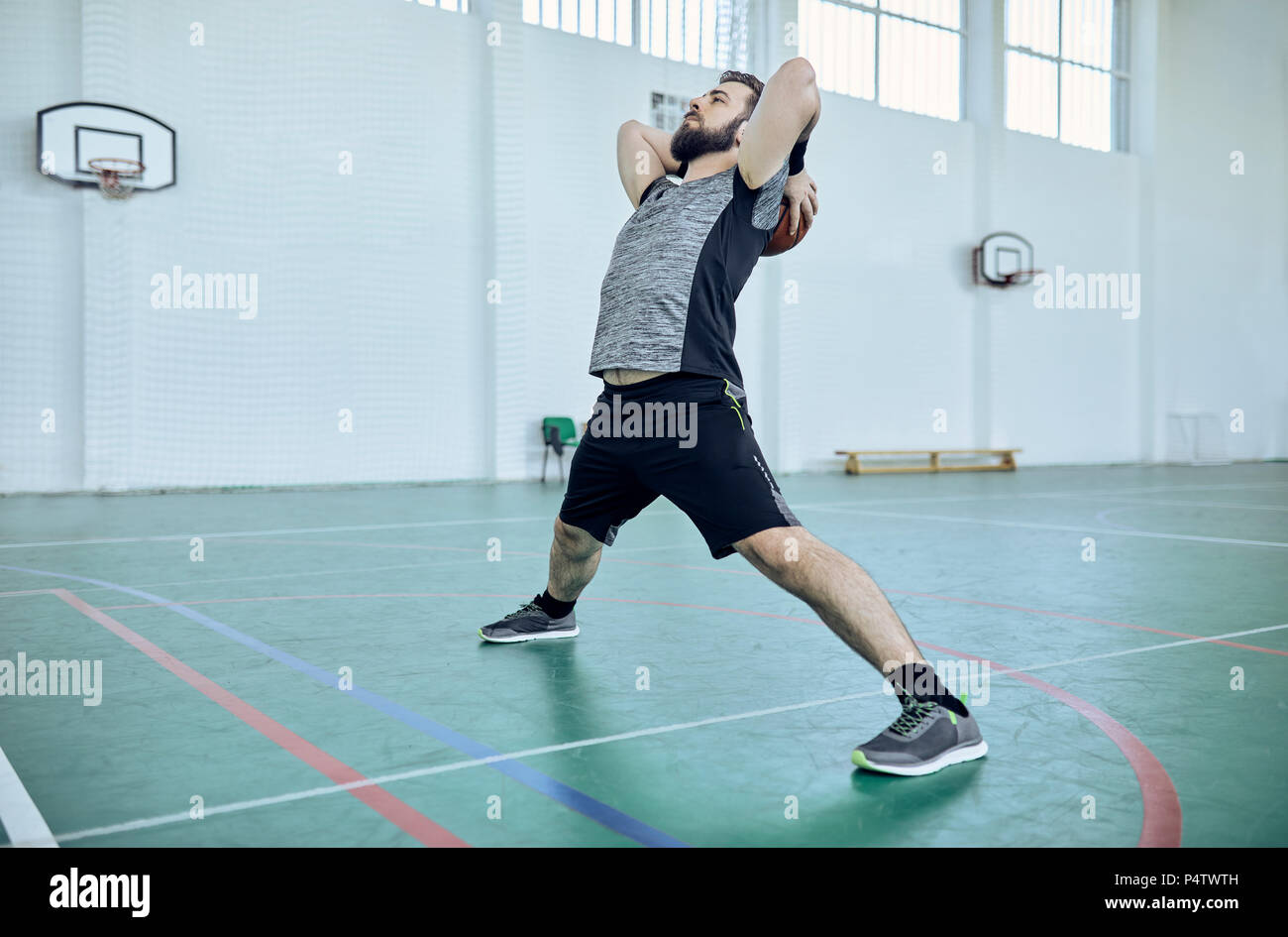 Mann mit Basketball, Stretching, Innenpool Stockfoto