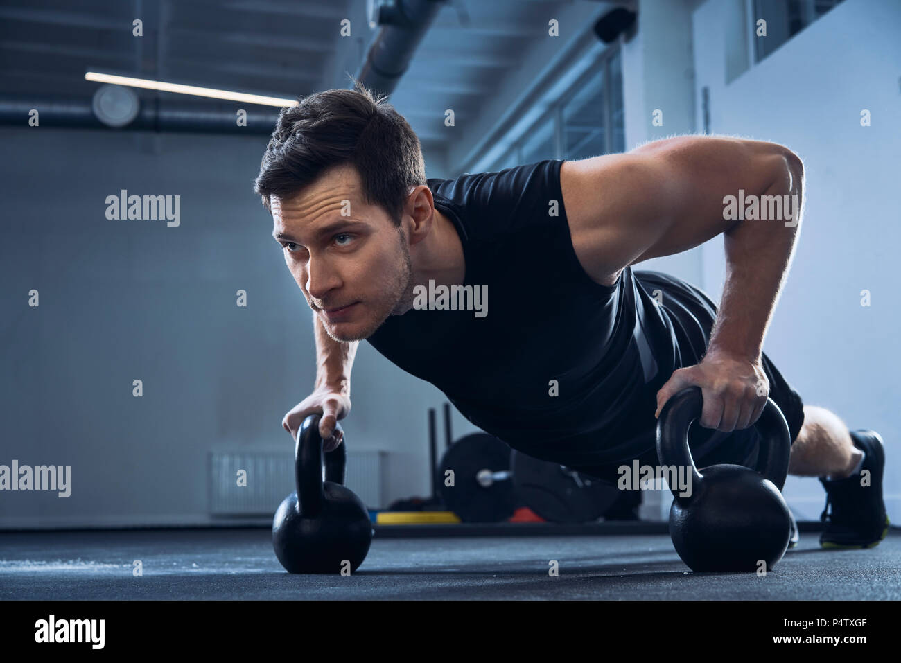 Mann tun pushups auf Kettlebells im Fitnessstudio Stockfoto