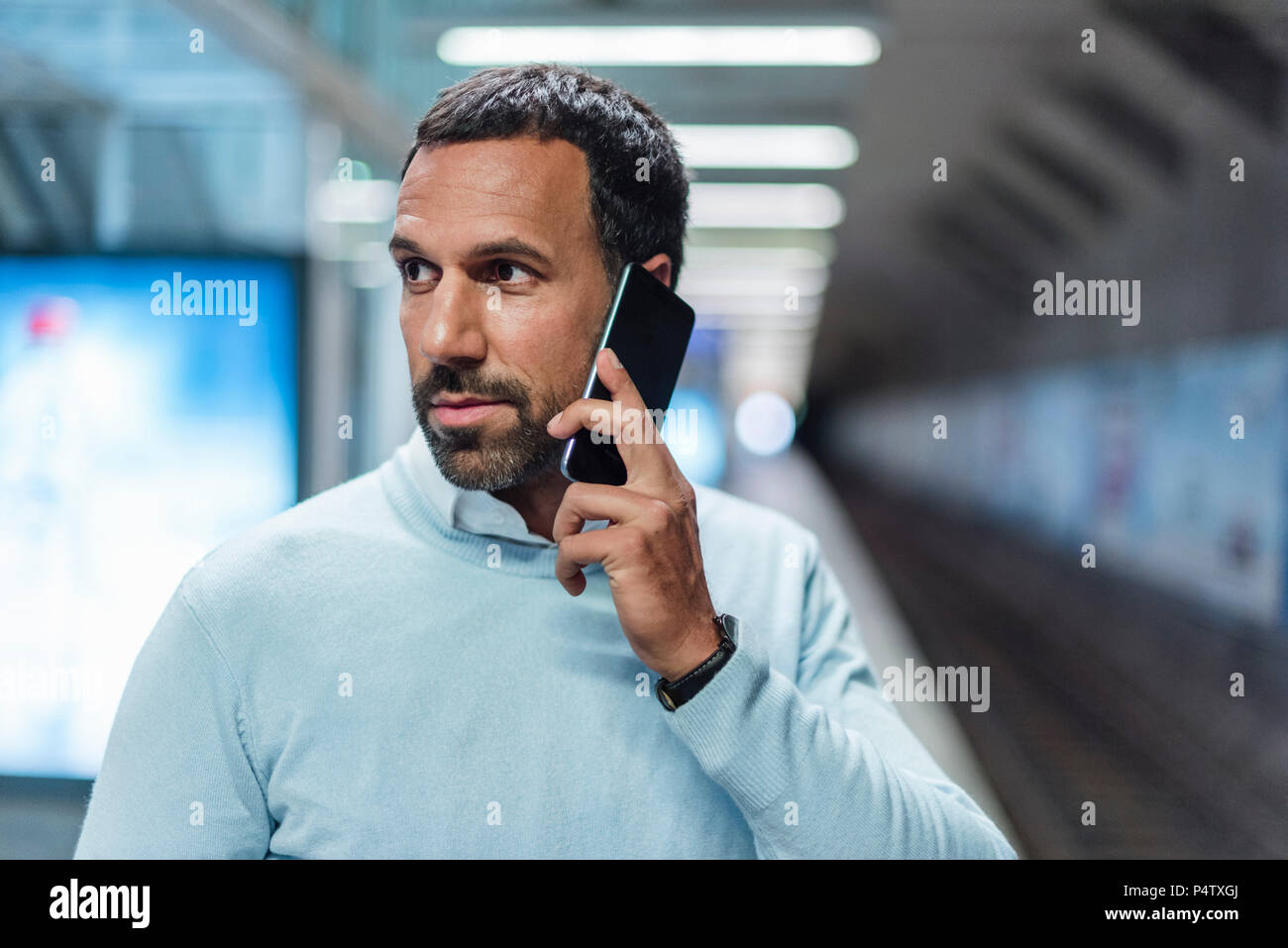 Geschäftsmann mit an der Metrostation smartphone Stockfoto