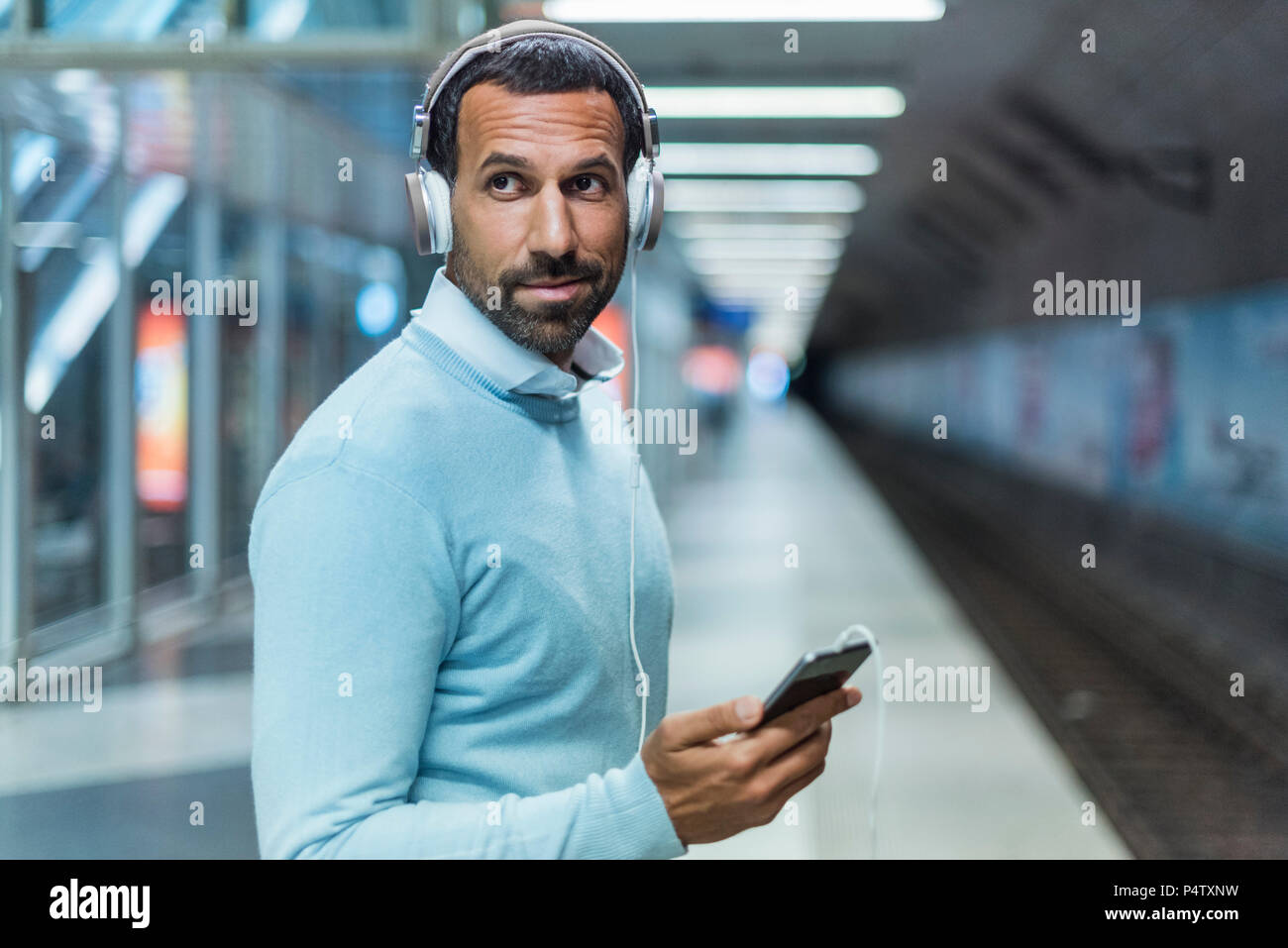 Geschäftsmann mit an der Metrostation smartphone Stockfoto