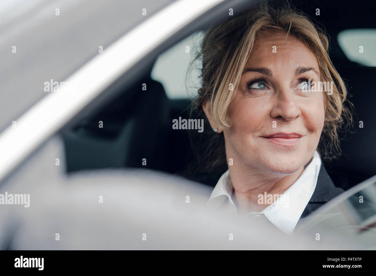 Portrait von lächelnden senior Geschäftsfrau im Auto. Stockfoto