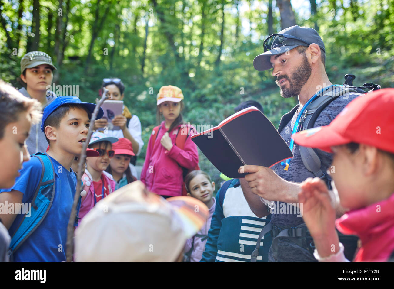 Mann Lesung für Kinder auf eine Entdeckungsreise im Wald Stockfoto