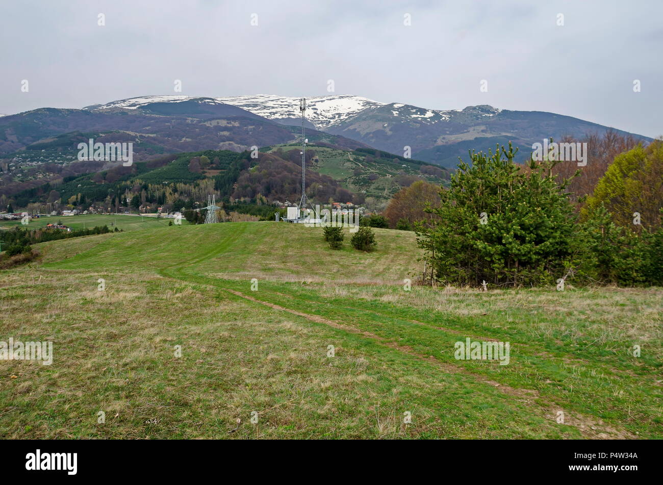 Ansicht mit Schnee oben, Frühling Fuß des Berges, Lichtung, mix Wald, Electric power transmission Line, Antenne und Wohnquartier in der Wit Stockfoto