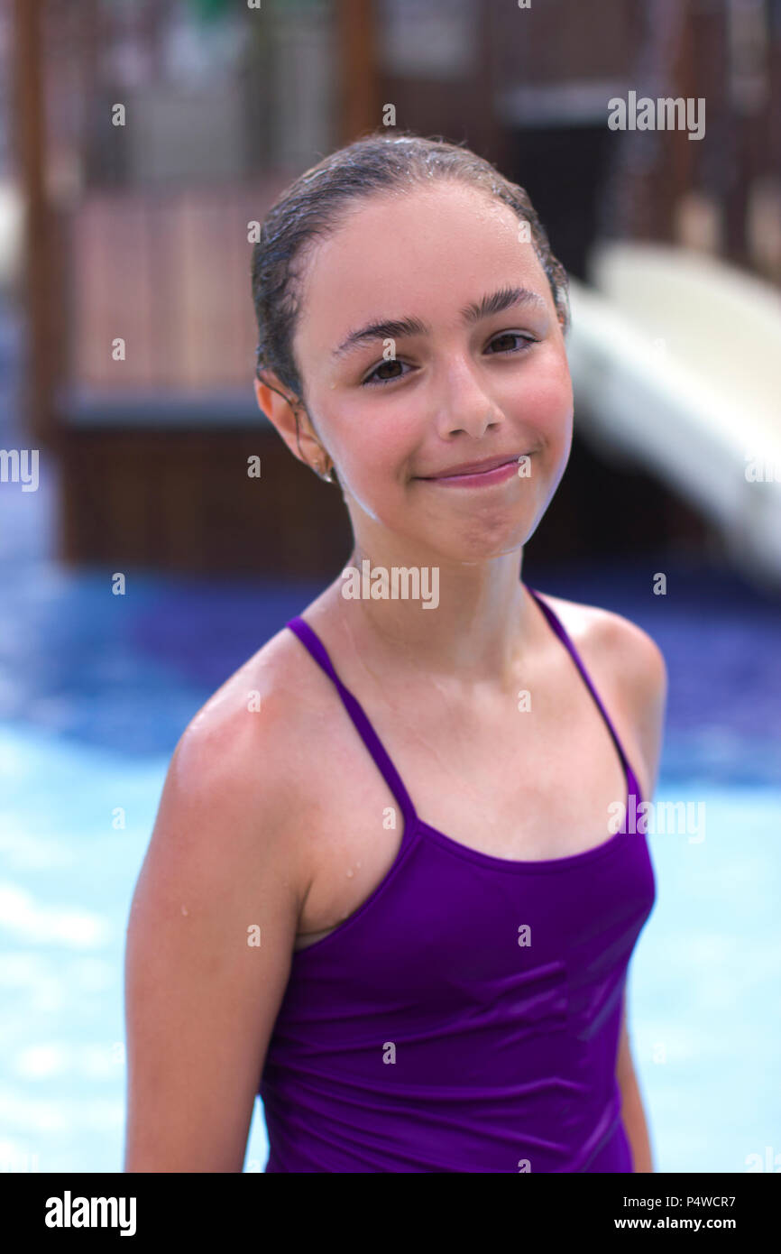 Schöne junge Mädchen in einem lila Badeanzug auf dem Hintergrund einer Pool  in einem Hotel Stockfotografie - Alamy