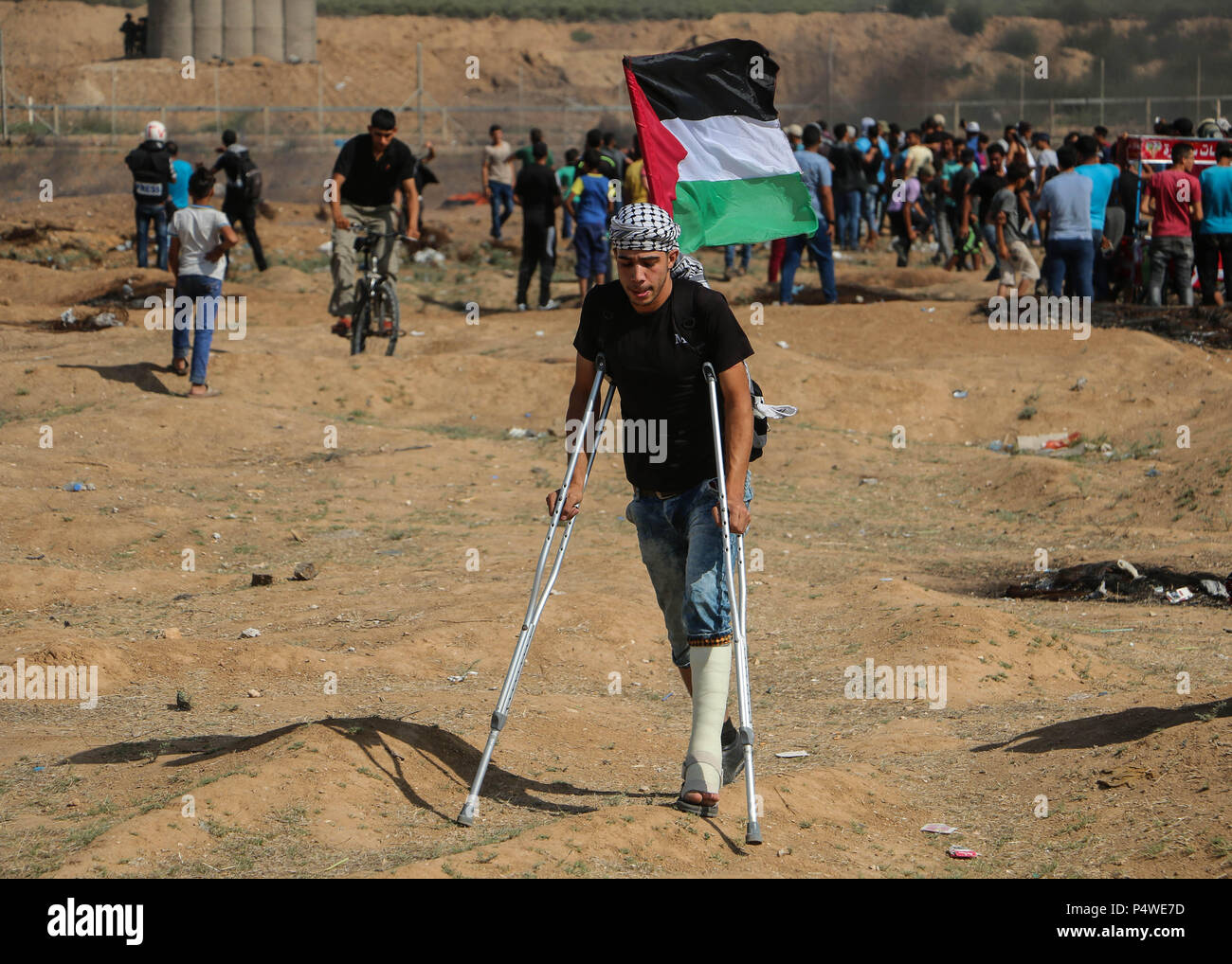 Eine verwundete palästinensische Jugend wirft die Flagge von Palästina östlich von Gaza-stadt. Auseinandersetzungen zwischen palästinensischen Zivilisten und israelische Soldaten brach erneut an der Grenze des Gaza Streifen und Isreal in der Nähe des Nahal Oz Ort östlich von Gaza-stadt. Die israelischen Streitkräfte verletzt viele palästinensische Zivilisten durch Brennen von scharfer Munition und Benzinkanister in die Demonstrantin, die im eigenen Land sind. Die Palästinenser protestieren gegen die Übertragung der Amerikanischen Botschaft nach Jerusalem und die Anerkennung Jerusalems als Hauptstadt von Israel durch den US-Präsidenten Donald Trump. Stockfoto