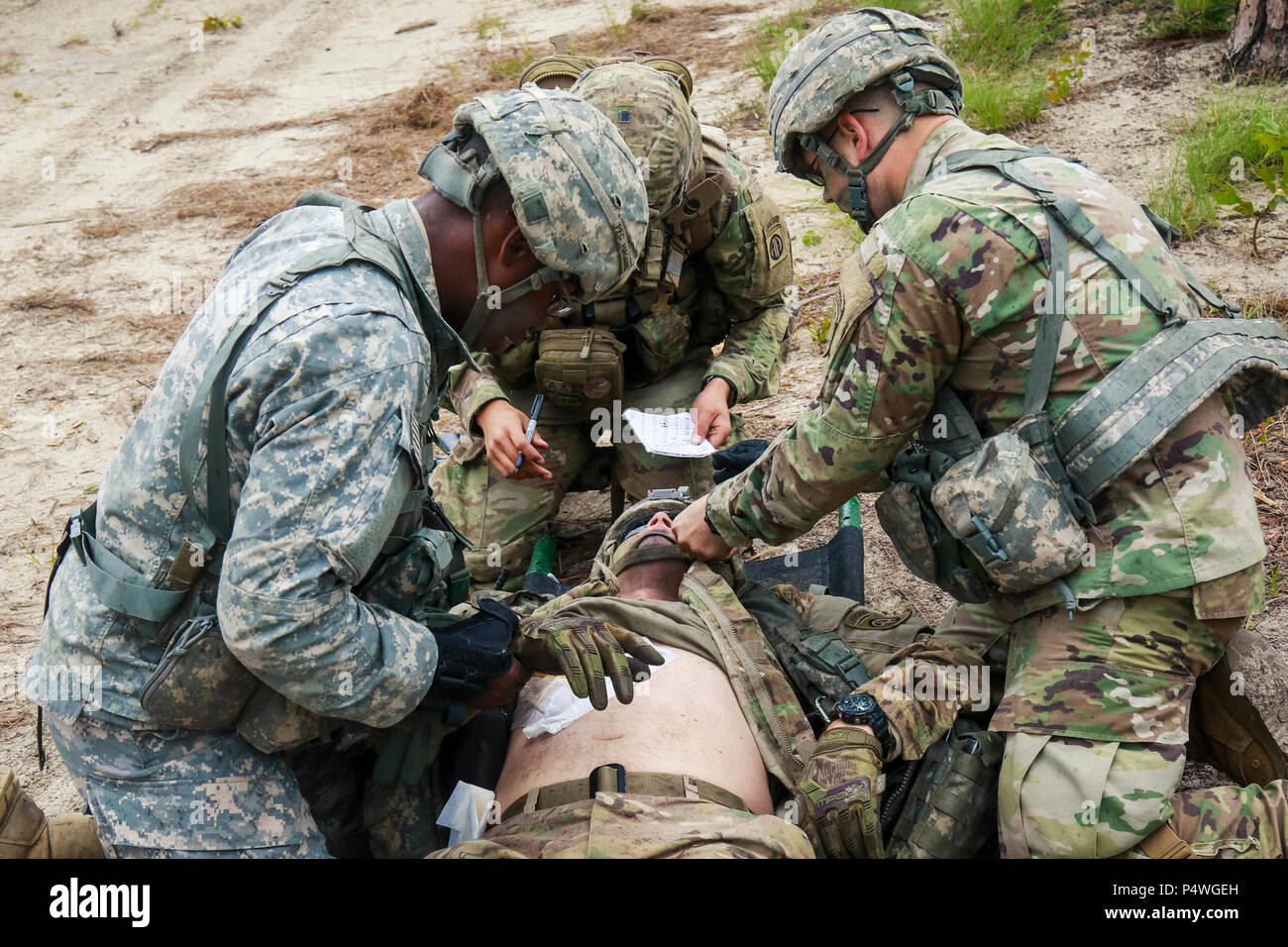 Soldaten zugeordnet 5. Staffel, 73 Cavalry Regiment, 3. Brigade Combat Team einen simulierten Unfall für die Extraktion vorbereiten, indem ein HH-60 Black Hawk Hubschrauber mit 'All-American DUSTOFF", 3. Allgemeine Unterstützung Aviation Battalion, 82nd Combat Aviation Brigade während Medevac Ausbildung bei Griffin helicopter Landing Zone auf Fort Bragg, N.C., Mai 9. Stockfoto