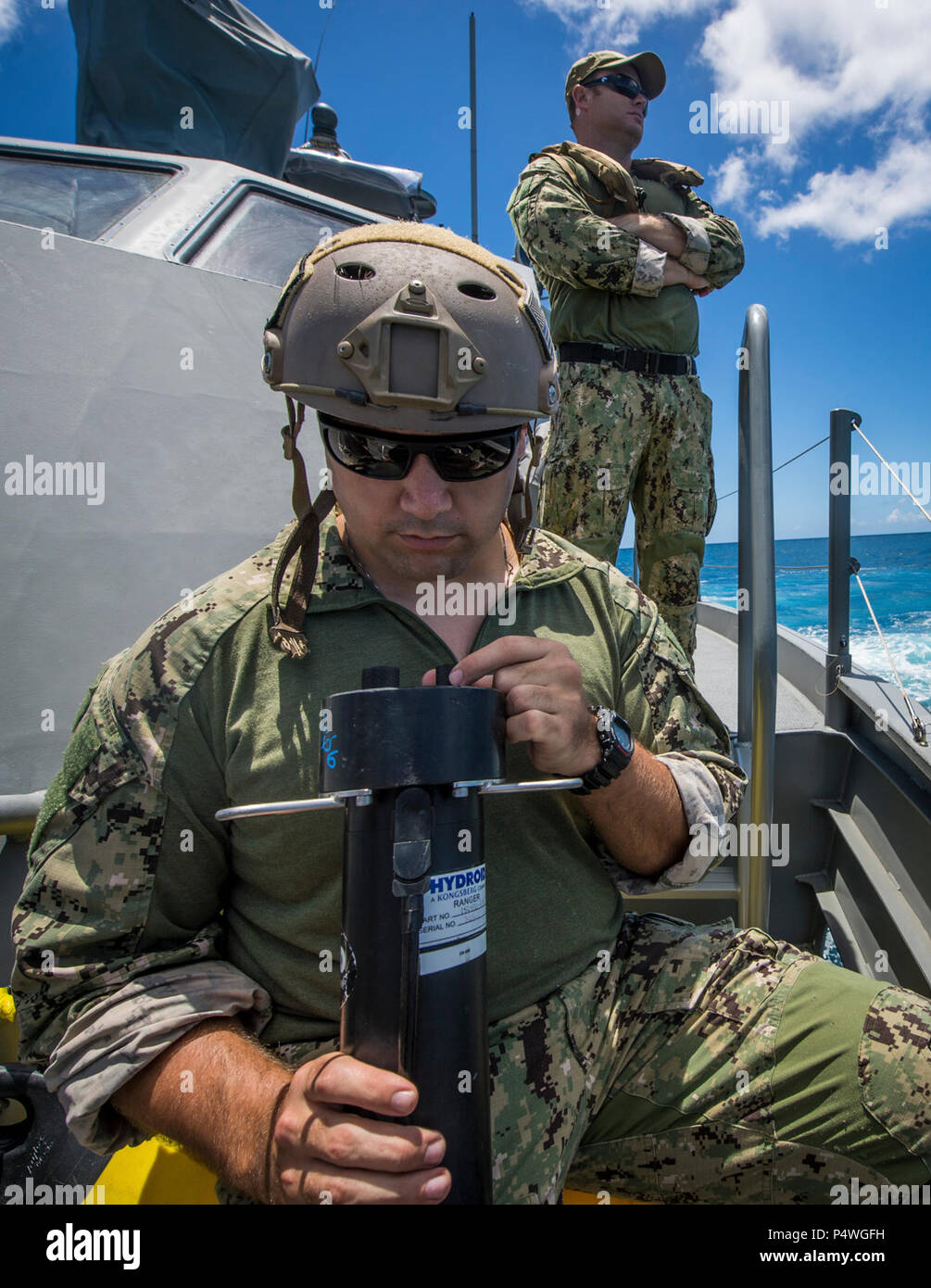 Ein Seemann, Explosive Ordnance Mobile Abfallbehälter 5 (EODMU5) Zug 142 zugewiesen verwendet einen akustischen Signalgeber an Bord ein Patrouillenboot Coastal Riverine Gruppe 1 Ablösung Guam MK VI, Status-Updates von ein unbemanntes Unterwasserfahrzeug vor der Küste von Saipan 9. Mai 2017 erhalten. EODMU5 testet derzeit seine Fähigkeit, Vermögen von verschiedenen Plattformen, einschließlich Hubschrauber bereitstellen und Patrouillenbooten, um seine adaptive Interoperabilität zu erhöhen. EODMU5 führt mine Gegenmaßnahmen, improvisierte explosive Gerätevorgänge, macht sicherere explosive Gefahren und entwaffnet Unterwasser Sprengstoffe wie Stockfoto