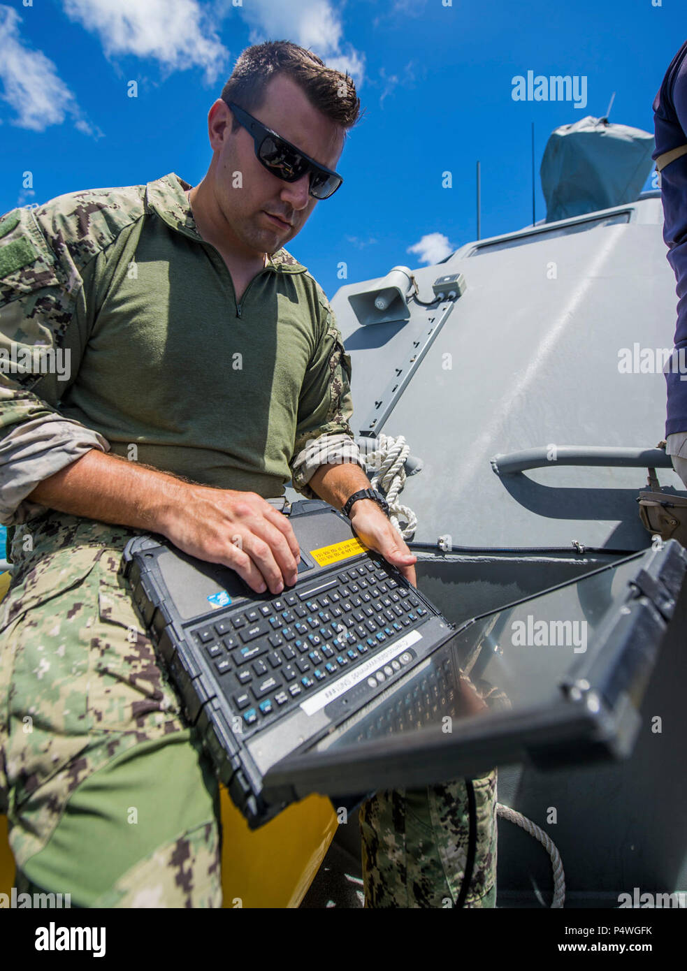 Ein Seemann, der auf die Beseitigung von Explosivstoffen Mobile Unit 5 (EODMU 5) Platoon 142 über ein Laptop an Bord eines Küsten Riverine Gruppe 1 Loslösung Guam MK VI Patrouillenboot Status Updates von ein unbemanntes Unterwasserfahrzeug vor der Küste von Saipan Mai 9, 2017 zu erhalten. EODMU 5 prüft derzeit die Möglichkeit, Vermögenswerte aus verschiedenen Plattformen, einschließlich Hubschrauber- und Patrouillenboote, die adaptive Interoperabilität zu erhöhen. 5 EODMU führt meine Gegenmaßnahmen, Improvised Explosive Device operations, macht sicher explosive Gefahren und entwaffnet Unterwasser sprengstoffe wie Minen. Stockfoto