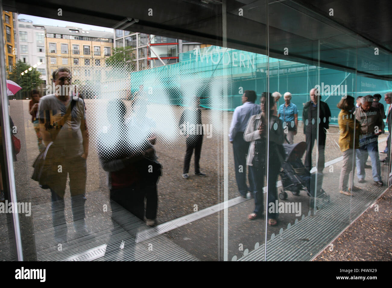 Die Menschen in der Warteschlange warten, Eingang für eine Ausstellung in der Tate Modern zu gewinnen. London, England, UK. Stockfoto