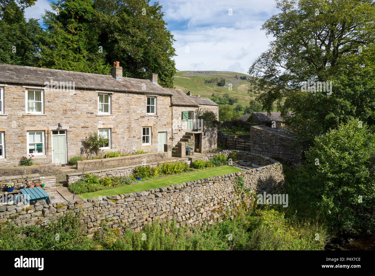 Häuschen neben dem Fluss Swale im Dorf Muker, Swaedale, North Yorkshire, England. Stockfoto