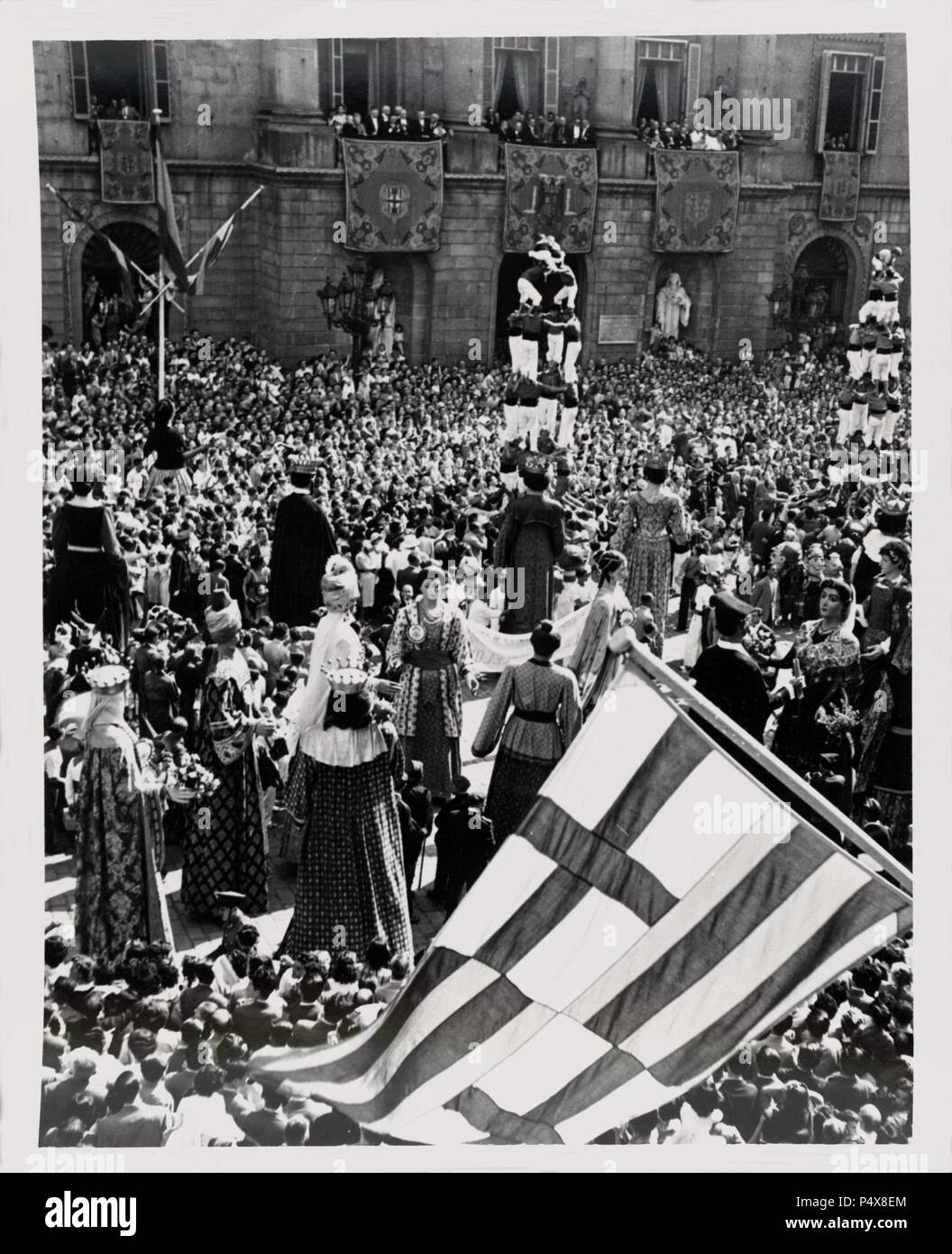 Baile de Gigantes y 'castellers'en la Plaza de San Jaime de Barcelona Frente al Edificio del Ayuntamiento. Años 1950. Stockfoto