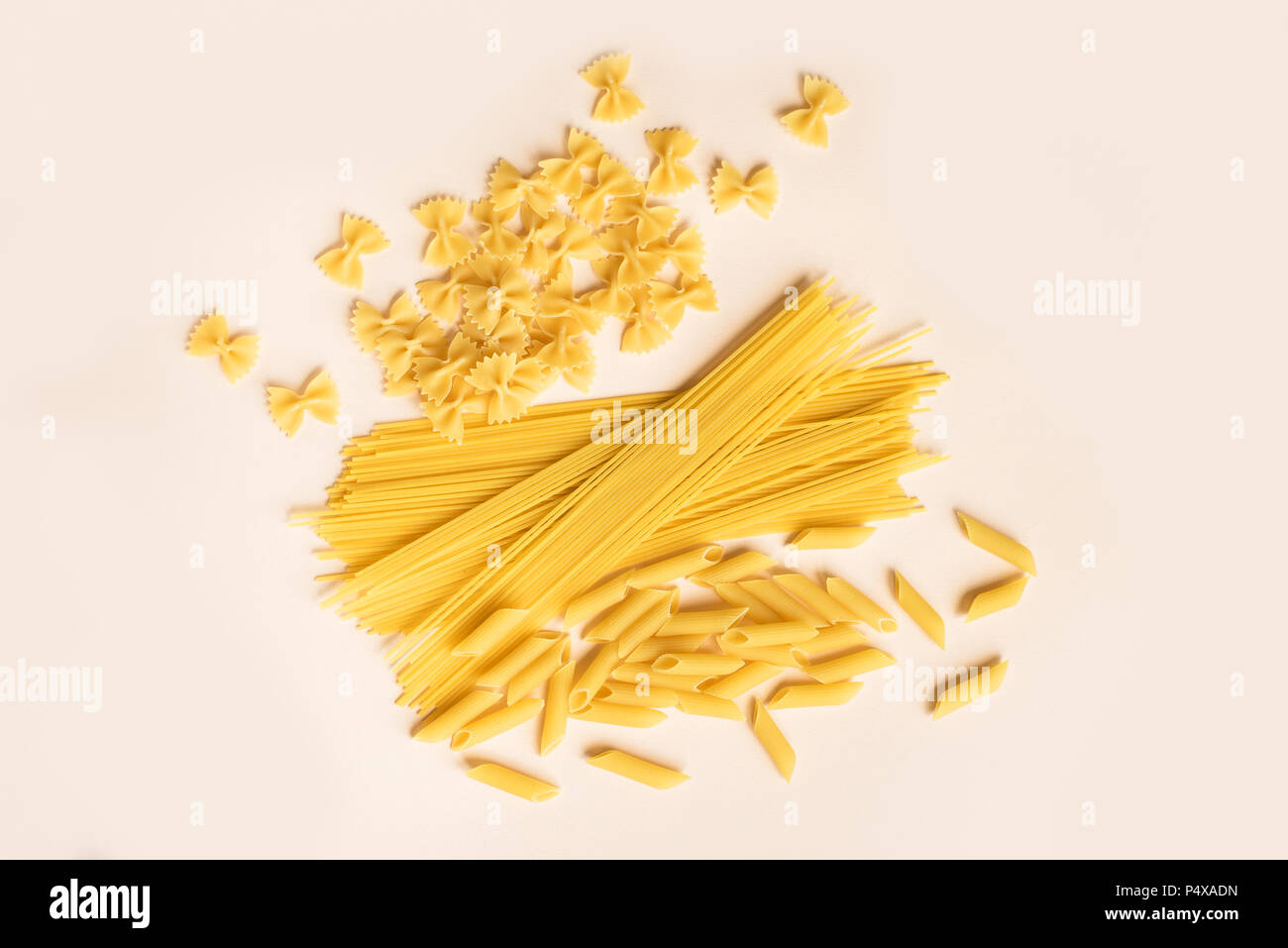 Verschiedene verschiedene Roh rohe Nudeln auf Rosa pastell Hintergrund. Italienische Pasta: Penne, Farfalle, Spaghetti. Stockfoto