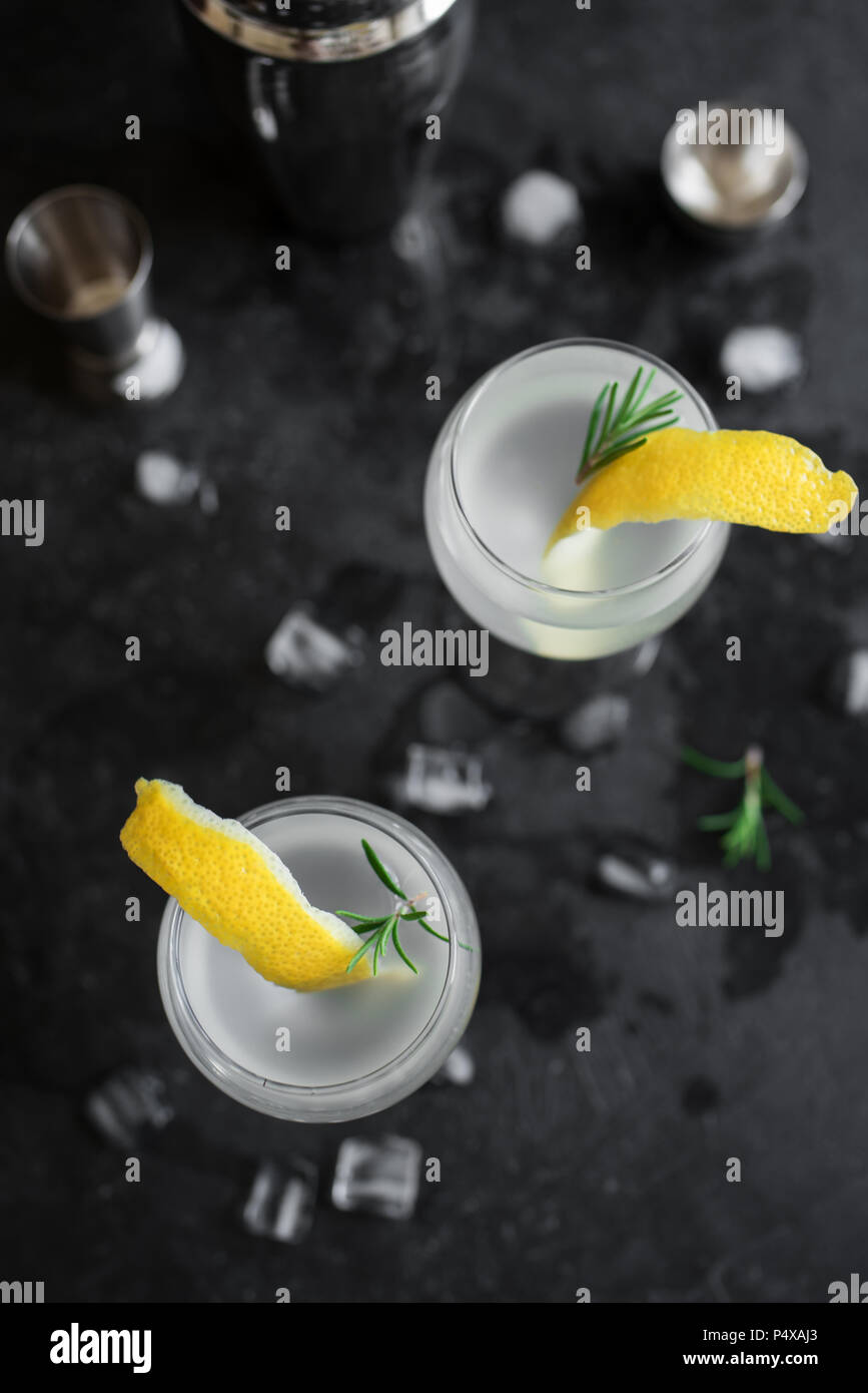 Alkohol Cocktail mit Zitrone, Rosmarin und Eis. Gin Tonic fizz oder Gimlet auf schwarzem Hintergrund, kopieren. Stockfoto