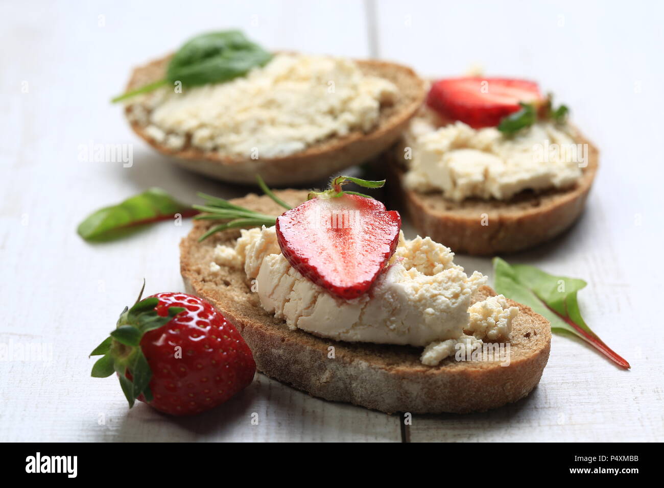 Scheiben Brot mit Käse und Erdbeeren auf die Oberseite. Stockfoto