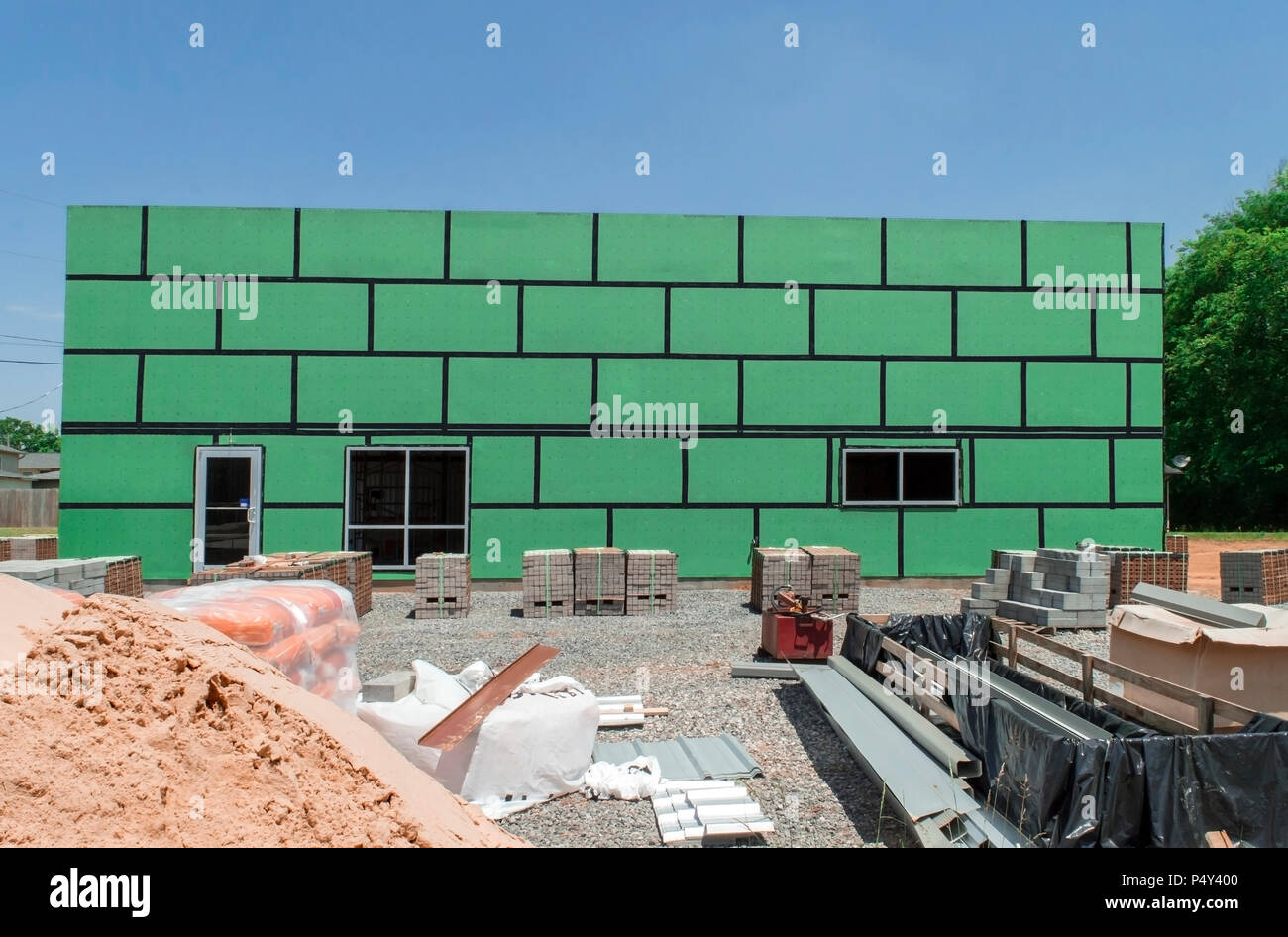 Horizontalen geraden auf Schuß auf ein im Bau befindliches Gebäude mit grünen Isolierung und die umliegenden Baustelle. Stockfoto