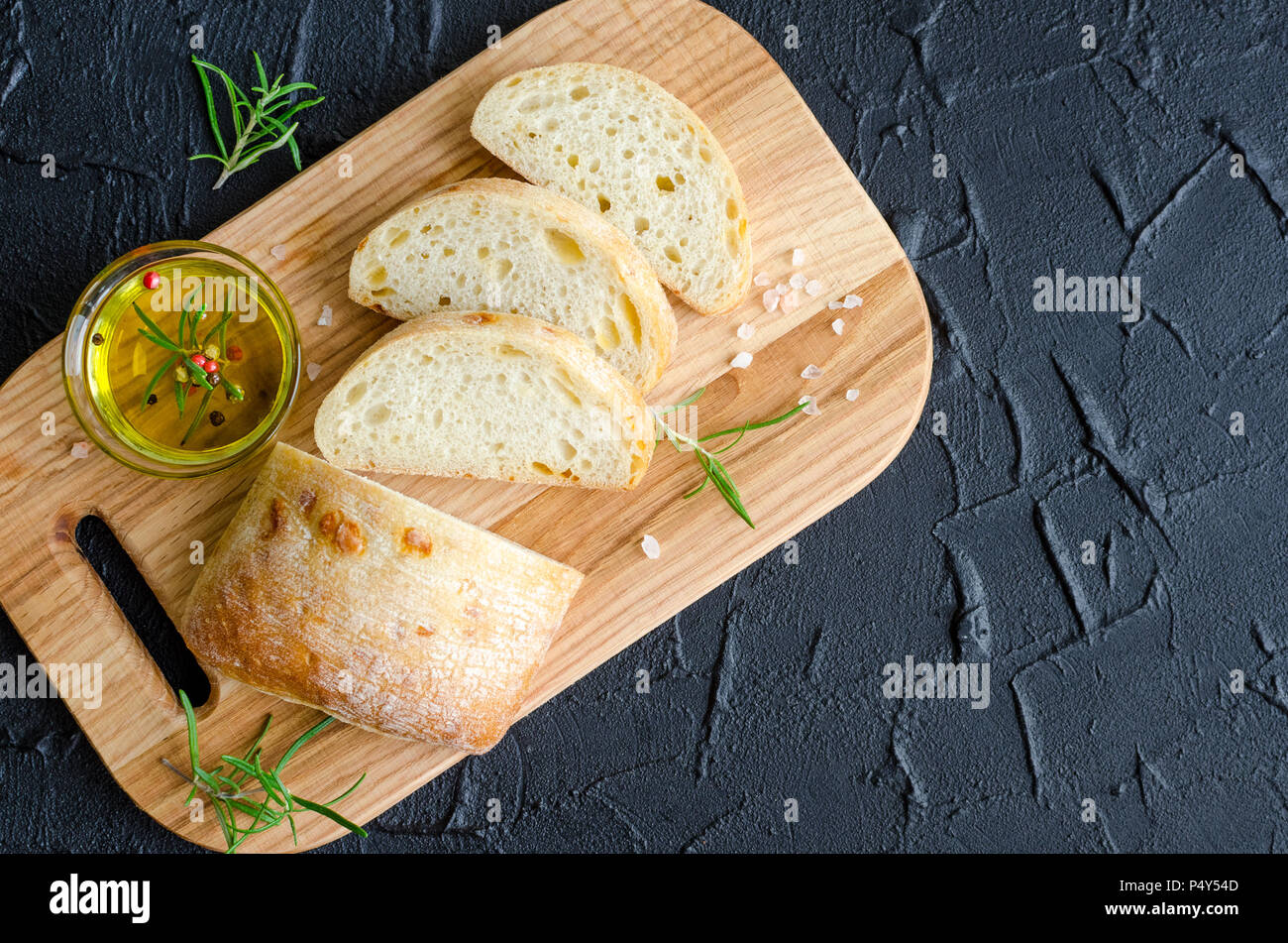 Frisch Gebackenes Ciabatta Brot Auf Holz Schneidebrett Mit Rosmarin Olivenol Und Salz Auf Dunklem Stein Schwarz Konkrete Tabelle Geschnitten Italienisches Essen Konzept Stockfotografie Alamy