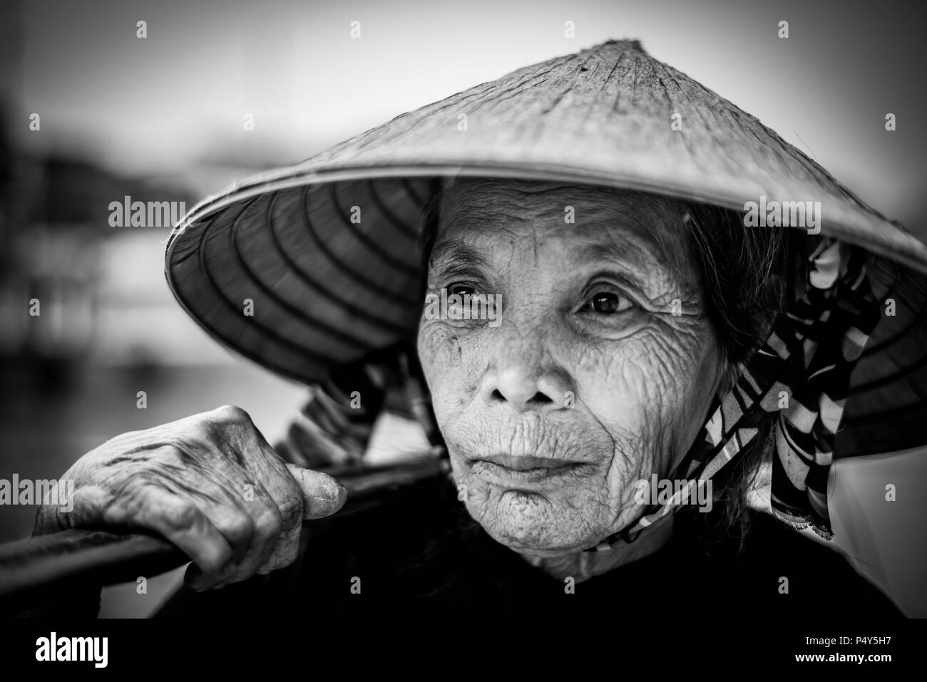 Alte freundliche Frau mit vietnamesischen Strohhut Stockfoto