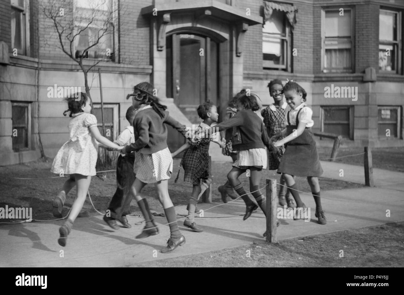 Gruppe von Mädchen spielen Ring-Around-a-Rosie auf Bürgersteig in "Black Belt" Nachbarschaft, Chicago, Illinois, USA, Edwin Rosskam für Office of War Information, April 1941 Stockfoto