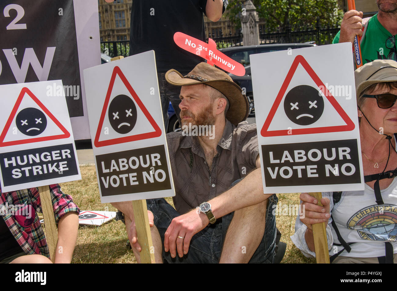 London, Großbritannien. 23. Juni 2018. Aktivisten gegen die Erweiterung des Flughafens Heathrow halten Plakate hoch, die Labour-abgeordneten dagegen bei einer Kundgebung in Parliament Square zu stimmen. Die dritte Start- und Landebahn wäre verhängnisvoll Staus und Lärm und Luftverschmutzung in und um London und einen dramatischen Beitrag zum Klimawandel. Die Teilnehmer enthalten einige, die im Hungerstreik außerhalb der Labour Party HQ für 14 Tage so weit gewesen. Die Credit: Peter Marschall/Alamy leben Nachrichten Stockfoto