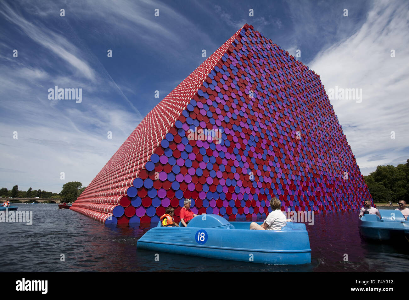 London, Großbritannien. 23. Juni 2018 Die Mastaba, eine temporäre Skulptur aus gestapelten Fässer in See Serpentine Lake im Hyde Park, wird von einem der berühmtesten Künstler der Welt, berühmt für ambitionierte im großen Maßstab funktioniert. Christo und seiner verstorbenen Frau Jean-Claude nahm eine Inspiration aus alten mastabas (Bänke) Strukturen, die sich in ersten städtischen civilizatons aus Mesopotamien stammt. Zwanzig Meter in die Höhe, die Struktur besteht aus 7506 horizontal gestapelt farbige Fässer. Die Skulptur fällt mit Serpentine Galerien Ausstellung von Christo und Jeanne-Claude durch die Verwendung von Fässern in ihrer Arbeit über th Cre Stockfoto