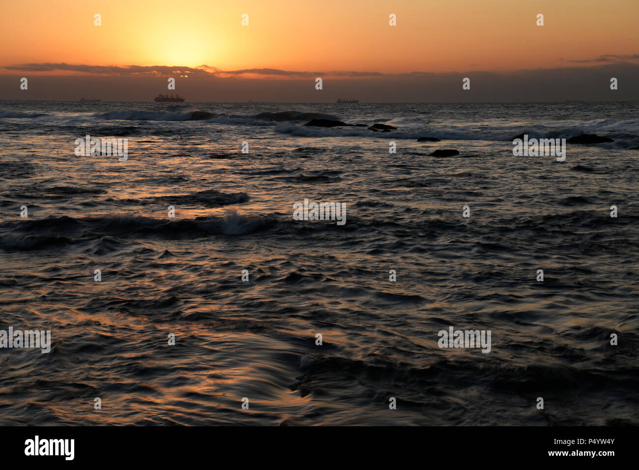 Landschaft, Durban, KwaZulu-Natal, Südafrika, golden Glow, Tagesanbruch, Sonnenaufgang, turbulenter Indischer Ozean, Blick auf Schiffe am Horizont, Umhlanga Rocks Strand Stockfoto