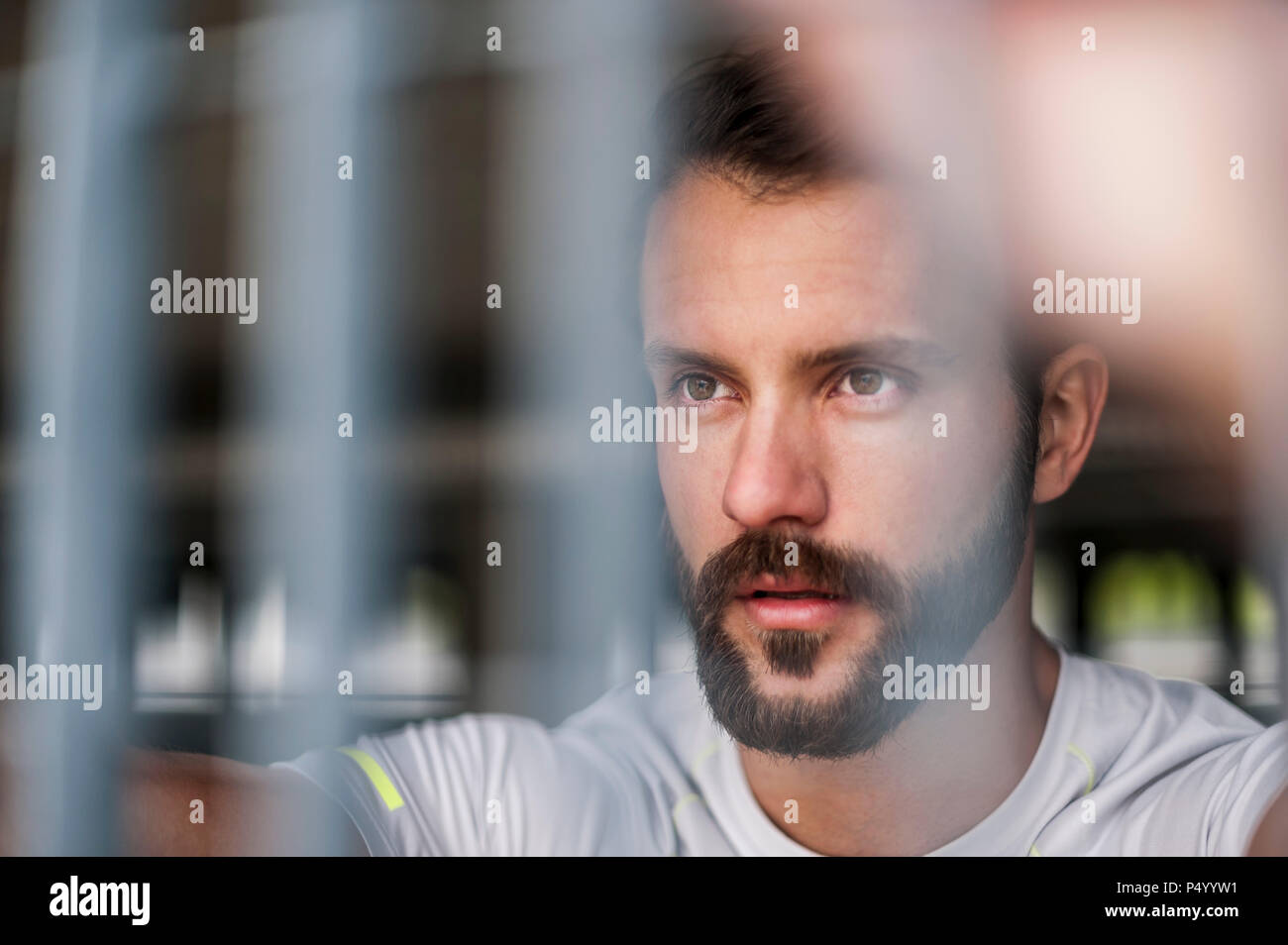 Portrait von zuversichtlich Athlet hinter Gitter Stockfoto