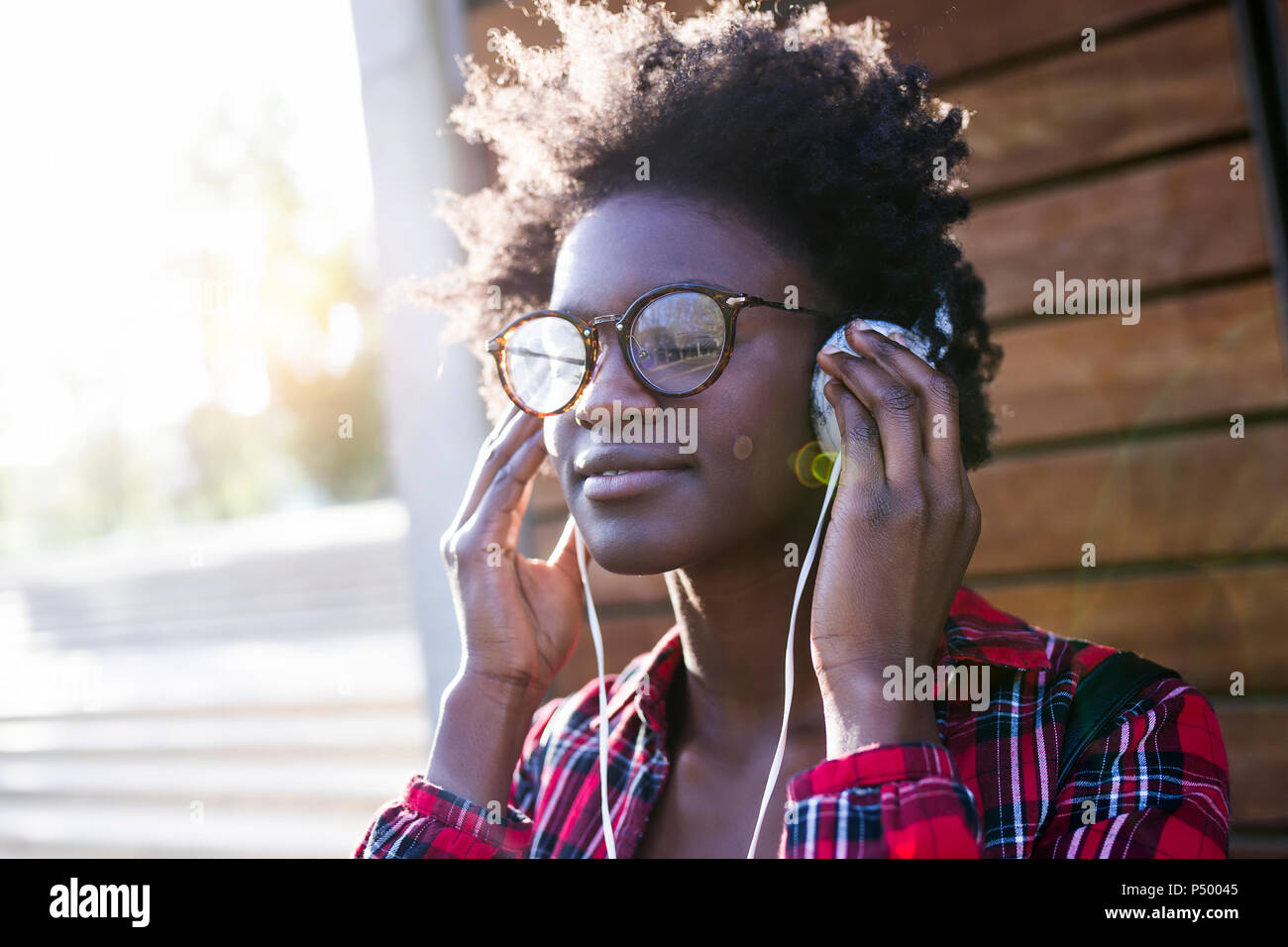 Porträt der lächelnde junge Frau Musik hören mit Kopfhörern Stockfoto