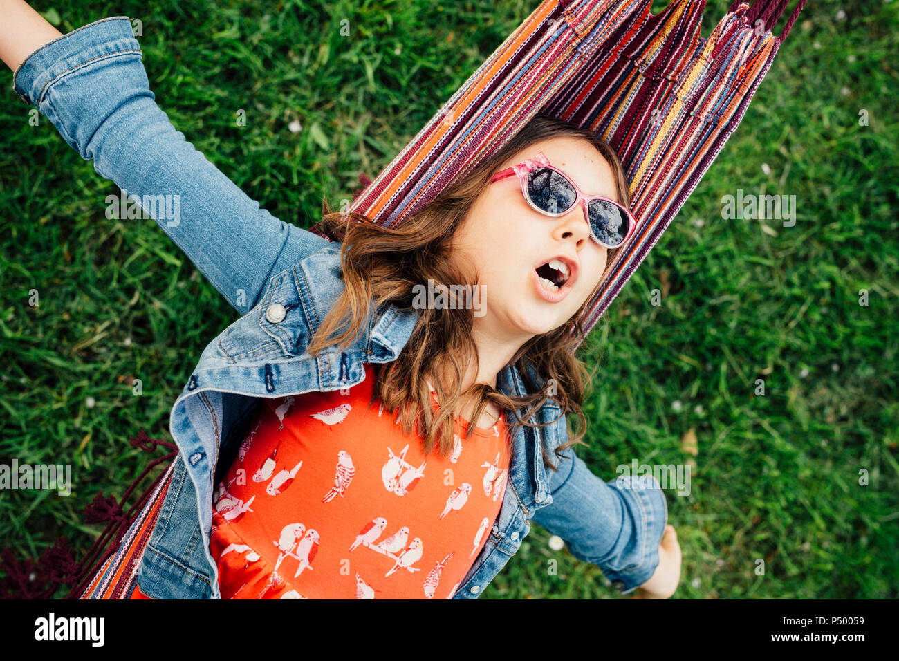 Portrait von singen Mädchen tragen Sonnenbrillen in der Hängematte liegend Stockfoto