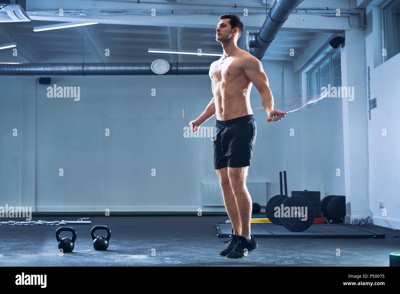 Athletischer mann Springseil im Fitnessstudio Stockfoto