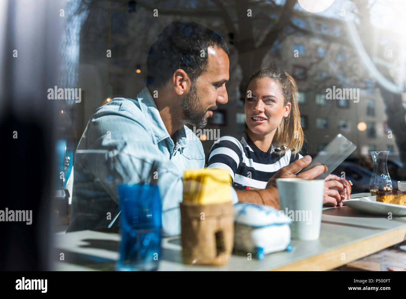 Junge Frau und Mann teilen Tablette in ein Cafe Stockfoto